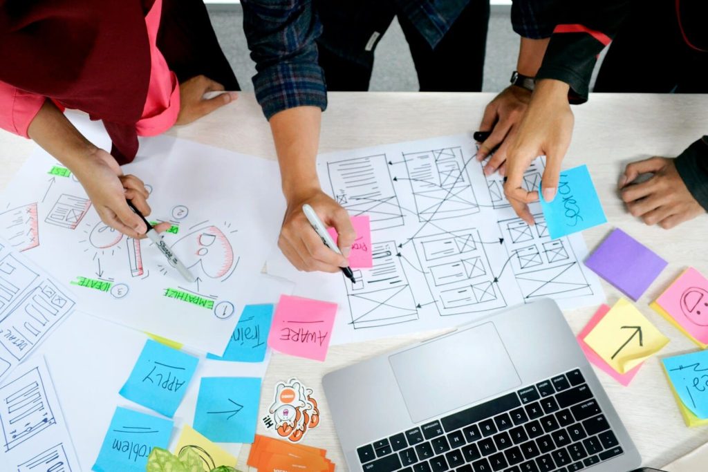 Personas trabajando sobre mockups de sitio web mobile